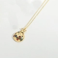 Macro shot of gold-plated mushroom pendant necklace with colorful inlaid crystals - Ladybug