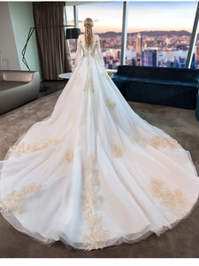 Luxurious long bridal train featuring golden floral lace embroidery and corset back detail