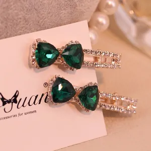 Paire de barrettes noeuds en cristal vert avec base dorée et strass étincelants