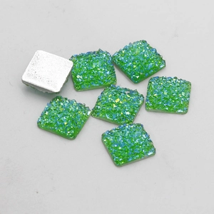 Macro shot of 12mm green resin glitter flatback squares with silver base for DIY jewelry