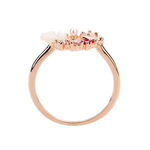 Dettaglio anello oro rosa con petali di fiori bianchi, perla e zirconi rosa micro