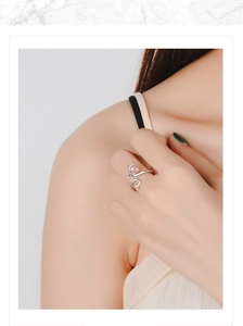 Detail of a silver cat ring with pink strawberry crystal on a model's hand