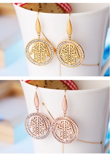 Macro detail of gold and rose gold Hamsa Hand earrings with micro zircon stone inlay