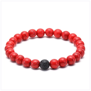 Detail of beaded bracelet with red marbled texture stones and black lava rock bead