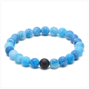 Detail of blue cracked agate beads and single black lava stone on a beaded bracelet