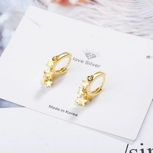 Elegant gold star drop earrings with polished finish on display card with white feathers