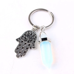 Detailed view of silver Hamsa hand charm and translucent white crystal on key ring