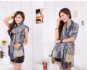 Detailed close-up showing blue and gold floral jacquard texture and tassels of the shawl