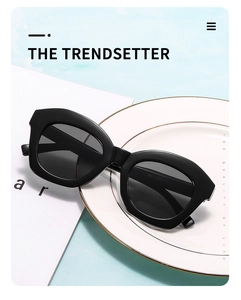 Classic black cat-eye sunglasses with matte finish on a minimalist white ceramic tray
