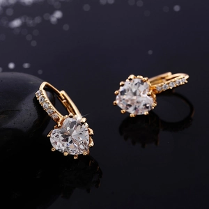 Macro detail of heart-cut cubic zirconia earring with gold plating and paved accents