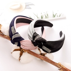 Detail of fabric knotted headbands with rhinestones in navy blue and black stripes