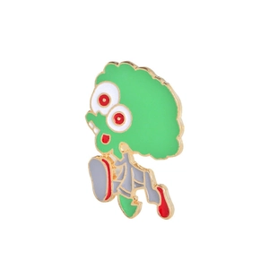 Detail of a cartoon zombie enamel pin with a green brain head and golden metal edges