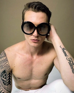 Detail of oversized round black sunglasses with dark gradient lenses on a model
