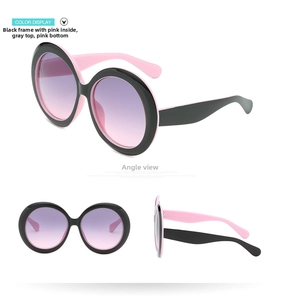 Detail view of oversized round sunglasses with black-pink frames and gradient lenses