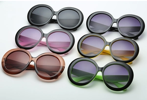 Close-up of retro oversized round sunglasses in black, purple, pink, and green colors