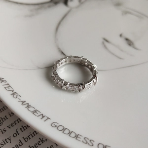 Detail of a 925 sterling silver ring with pavé diamonds on an elegant ceramic plate