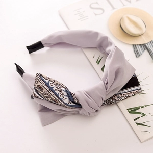 Detail of light purple bow headband with black and white pattern on a white desk