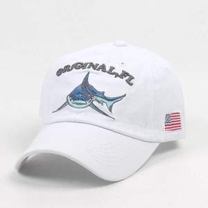 Detail of embroidered shark and original letters on white vintage cotton baseball cap