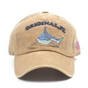 Close-up of shark embroidery and American flag patch on washed khaki cotton baseball cap