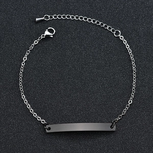 Close-up of minimalist stainless steel ID bracelet with rectangular plate and lobster clasp