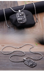 Detail of vintage punk skull relief pendant made of durable stainless steel with twist chain