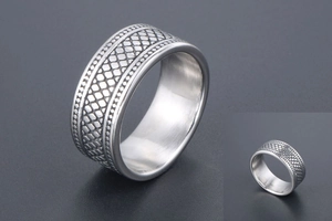Vue macro d'une bague vintage argentée avec texture peau de serpent et bords perlés