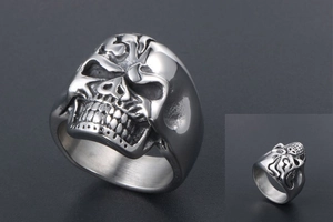 Detailed view of skull ring showing front 3D carving and side profile details on dark background