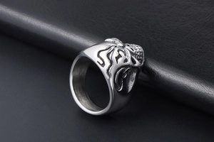 Macro detail of silver stainless steel skull ring with flame embossed textures