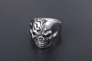 Macro close-up of gothic skull ring showing detailed metal carving and punk textures