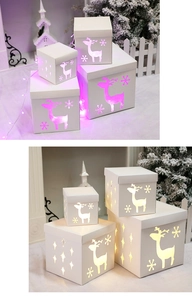 Detail of Christmas gift box with reindeer cutout and warm glowing LED light effects