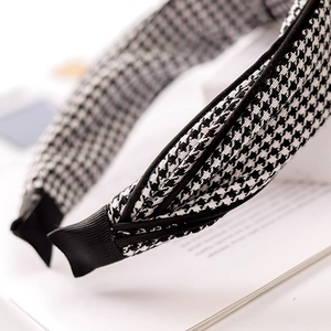 Detail of black and white houndstooth knotted headband on an open book page