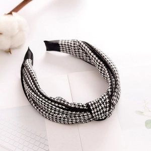 Detail view of the knotted top and houndstooth fabric texture of the wide headband