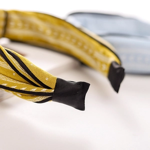 Macro shot of yellow fabric headband end featuring detailed black and white texture