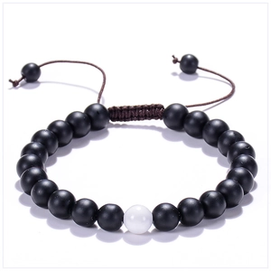 Detail of adjustable braided cord on beaded bracelet with matte black and white stones