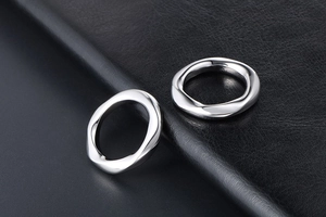 Macro d'anneaux en acier titane argenté au design torsadé géométrique sur cuir noir