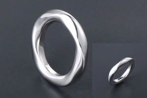 Gros plan d'une bague minimaliste torsadée en acier titane avec une finition polie miroir
