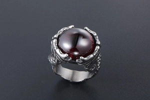 Detailed close-up of a dragon claw ring with a large round ruby red gemstone
