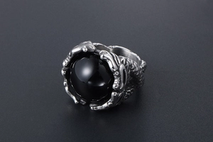 Detail of vintage silver dragon claw ring holding a polished black gemstone inlay