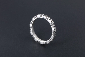 Macro shot of a silver titanium steel skull ring showing detailed metal texture and design