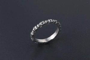 Detail of silver titanium steel ring featuring 3D skull relief in punk style