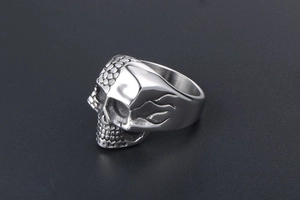 Macro shot of silver titanium ring with gothic double skull and flame engravings