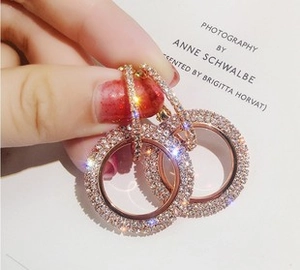 Macro shot of rose gold round crystal earrings with shimmering white rhinestones detail