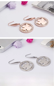 Vue détaillée des boucles d'oreilles rondes en or rose et argent avec strass et ange