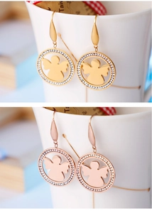 Détail de boucles d'oreilles ange en or et or rose avec pavé de cristaux brillants