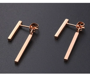 Macro detail of rose gold double bar earrings with polished finish and butterfly back