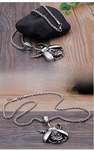 Detail of steampunk beetle pendant with mechanical gear core and steel wheat chain