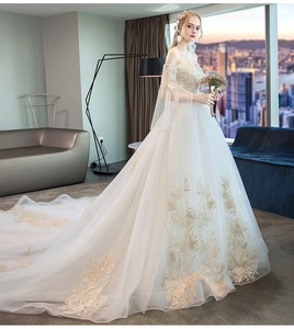 Detailed embroidery on light champagne tulle bridal gown with an elegant long train