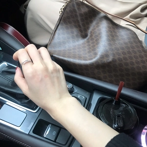 Sparkling silver snake ring with crystals worn on hand in a premium car interior setting