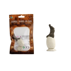 Detail view of hatching crocodile egg toy model with original packaging on white background