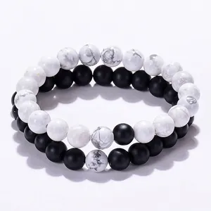 Detail of white turquoise and matte black agate beaded bracelets set with elastic cord